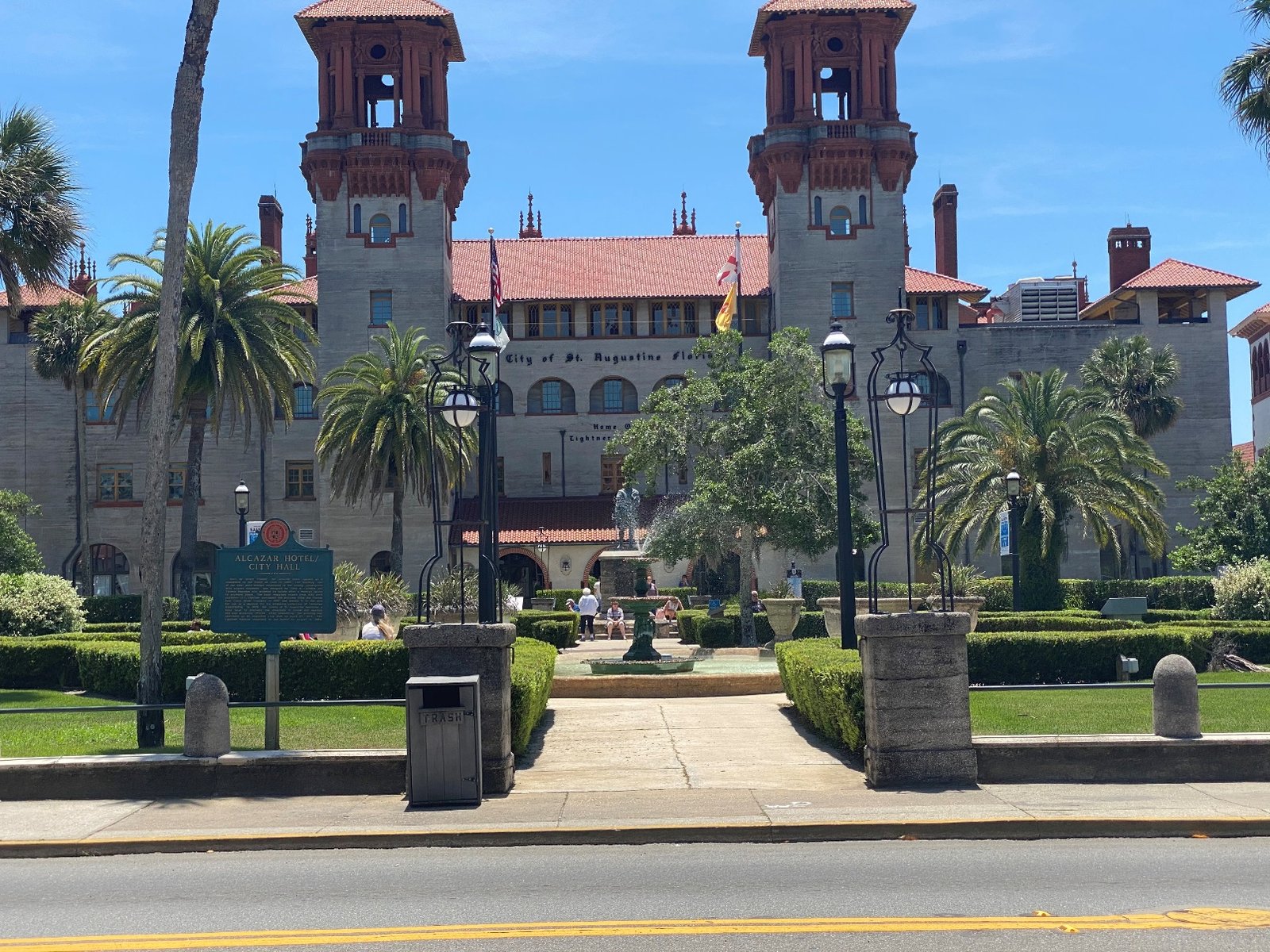 Lightner Museum with a red roof and a fountain and palm trees Description automatically generated