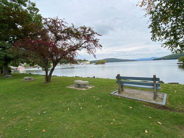 A bench next to a lake

Description automatically generated