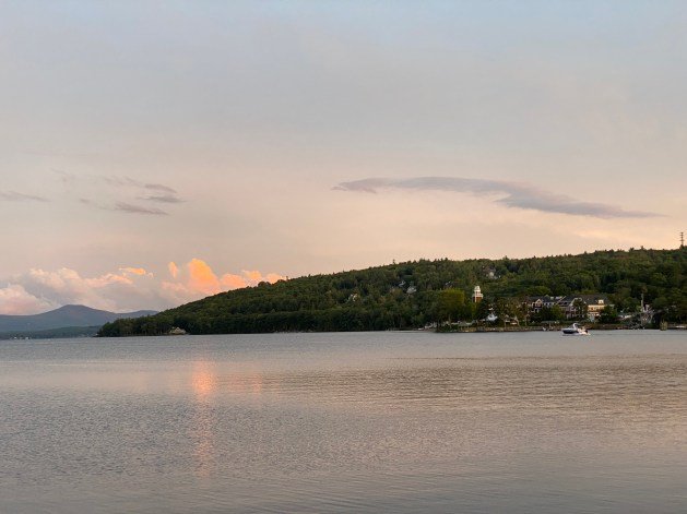 A body of water with a hill in the background

Description automatically generated