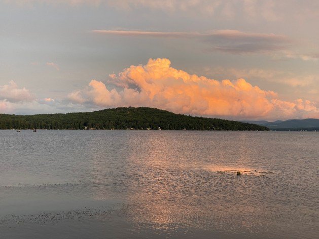 A body of water with a hill in the background

Description automatically generated