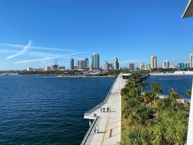 A long dock with a city in the background

Description automatically generated