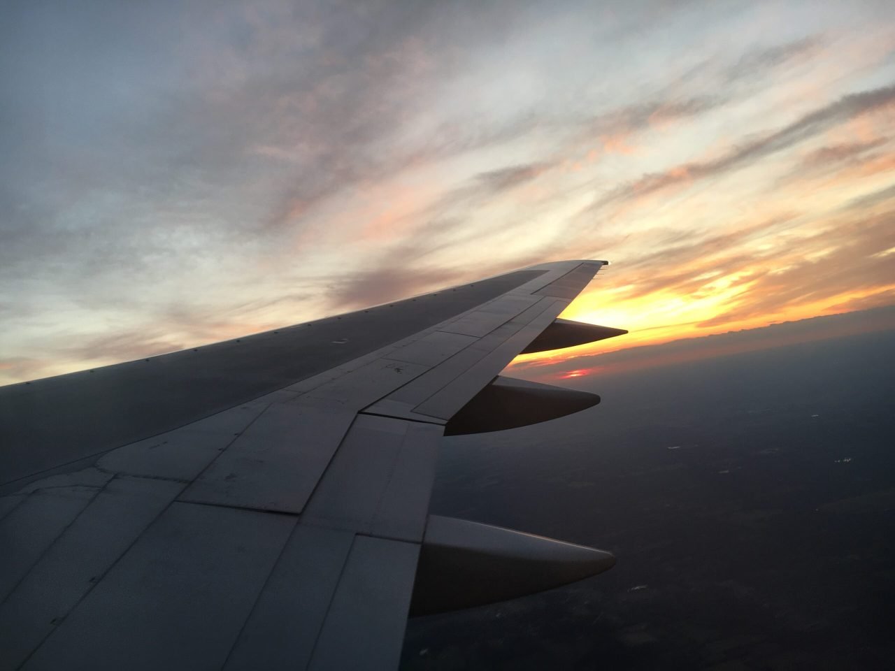 An airplane wing in the sky Description automatically generated