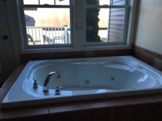 A bathtub with a window
Description automatically generated