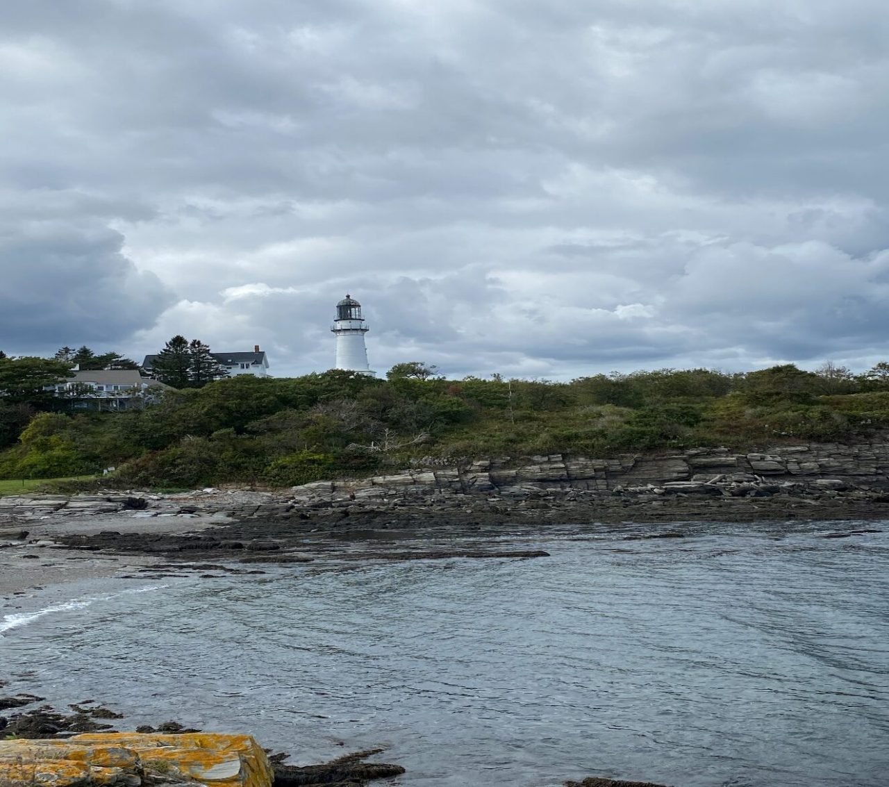 A body of water with a lighthouse in the distance
Description automatically generated