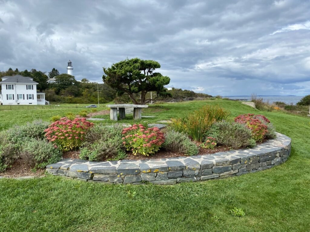 A circular stone garden with flowers and a bench Description automatically generated with medium confidence