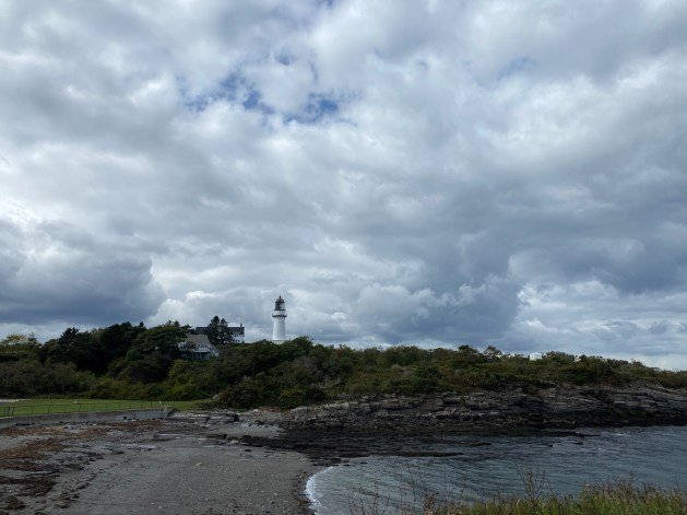 A lighthouse on a rocky shore
Description automatically generated