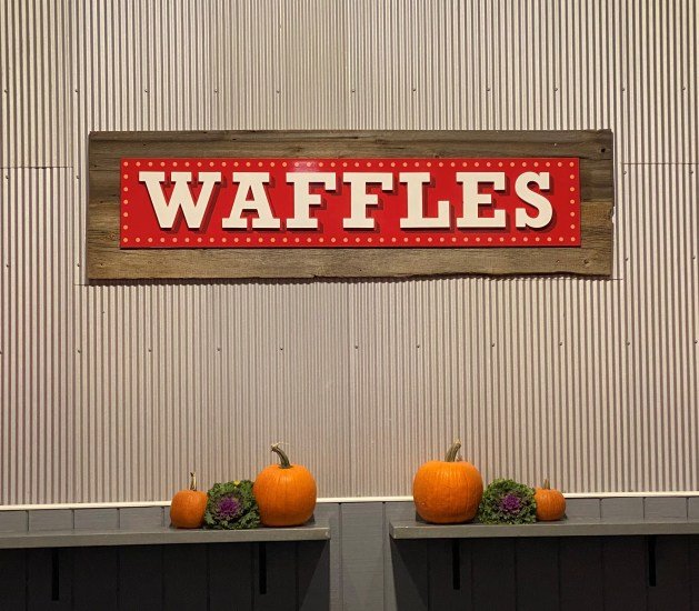 A sign on a wall with pumpkins
Description automatically generated