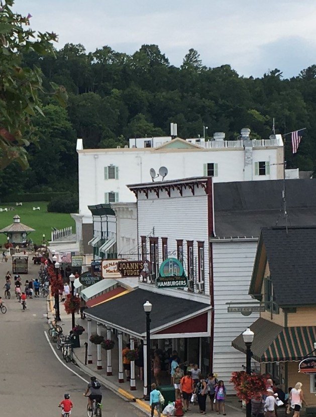 A street with shops and people walking on it

Description automatically generated