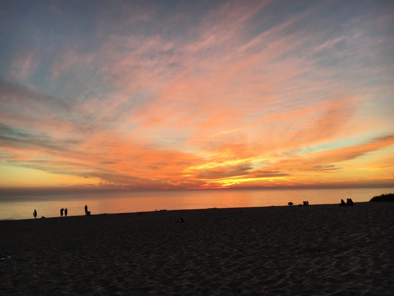 A sunset over a beach
Description automatically generated