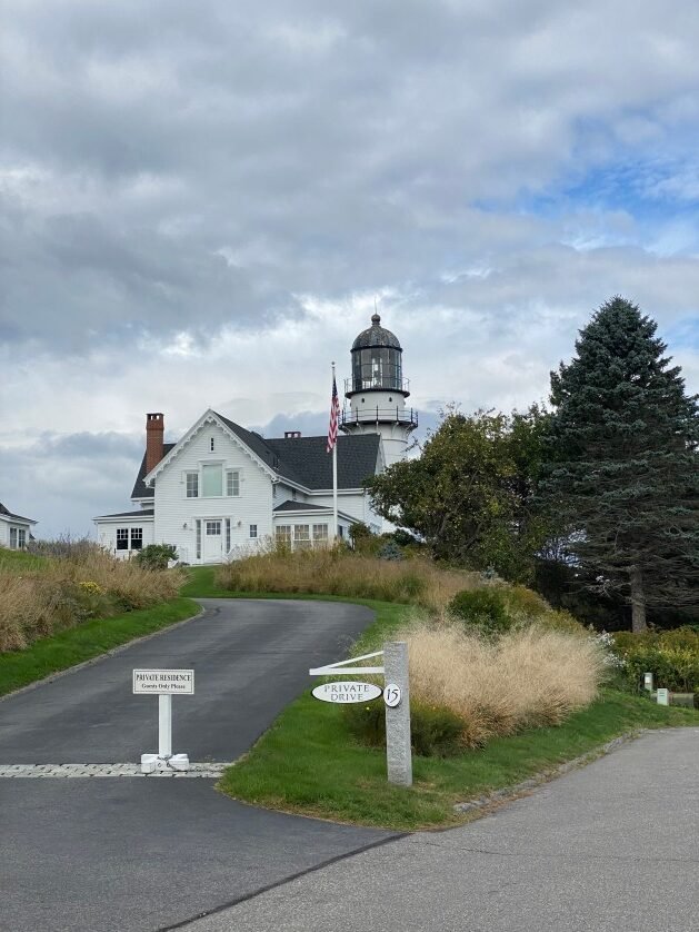 A white house with a lighthouse on the side
Description automatically generated