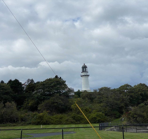 A white lighthouse in the distance
Description automatically generated
