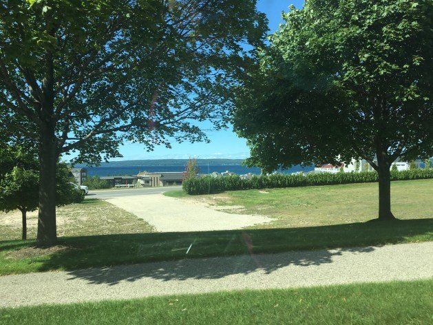 park with trees and distant bay in background.