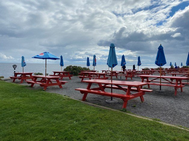 Picnic tables and umbrellas on a beach
Description automatically generated