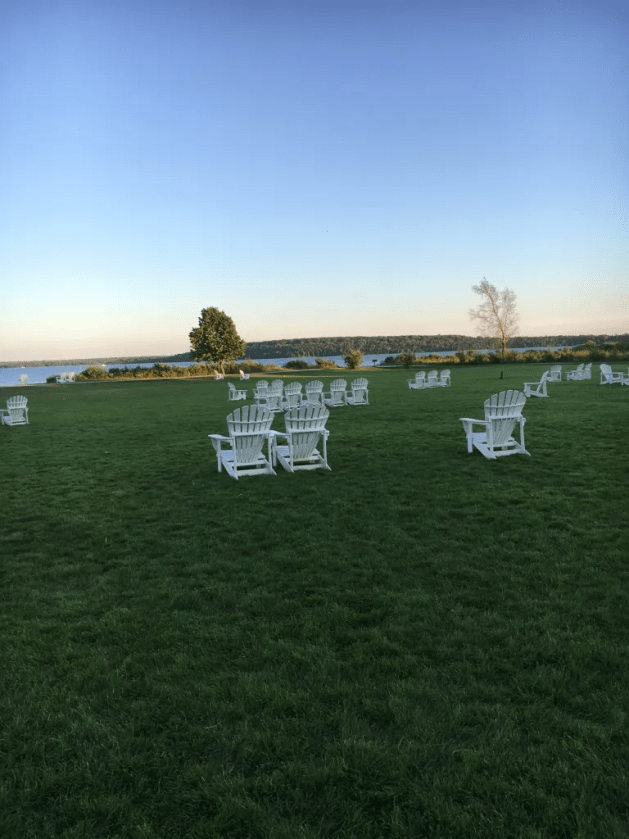A group of white chairs on a grassy field

Description automatically generated