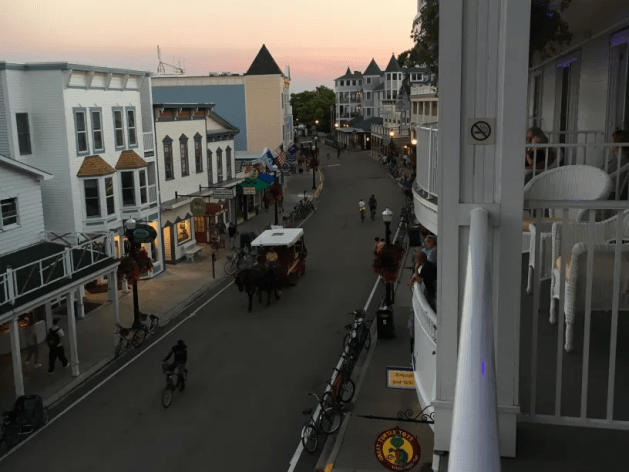 A street with people and horses and people on it

Description automatically generated
